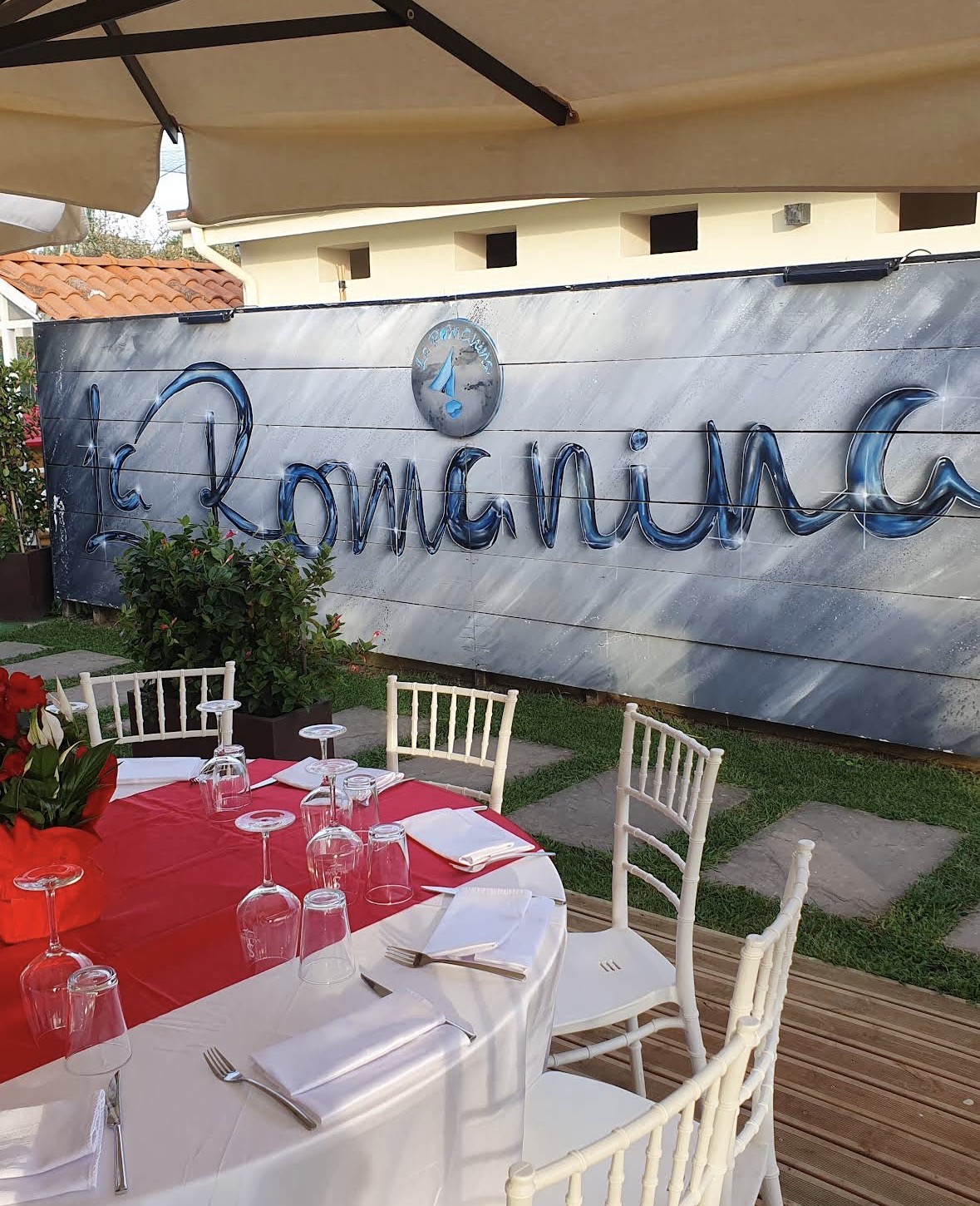 Tavolo apparecchiato con insegna La Romanina